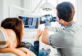 a dentist showing a patient her X-rays