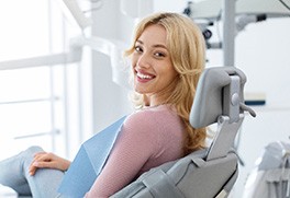 a smiling woman sitting in a dental chair