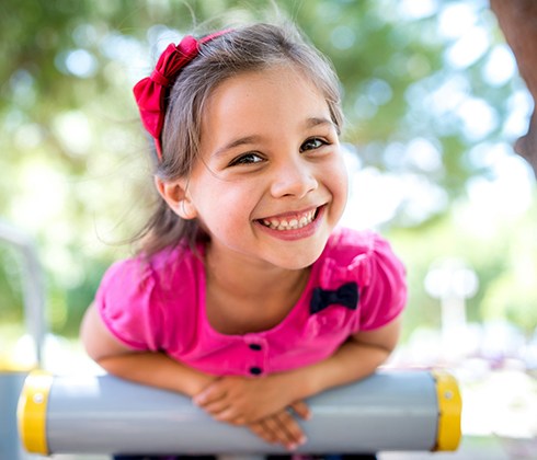 Young girl smiling outdoors after children's dentistry