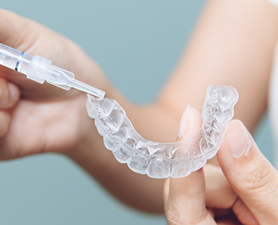 Close-up of hands holding tray for teeth whitening