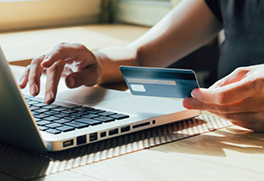 Typing on computer and holding credit card