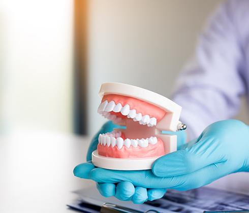 dentist holding dentures in hand 