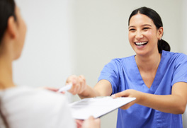 a dental team member handing a patient forms