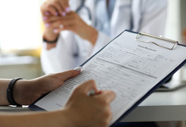 a patient filling out forms on a clipboard