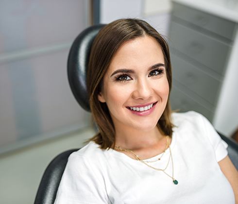 Woman smiling in dental chair for emergency dentistry