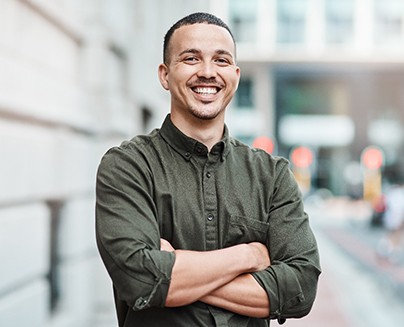 a smiling man with his arms crossed
