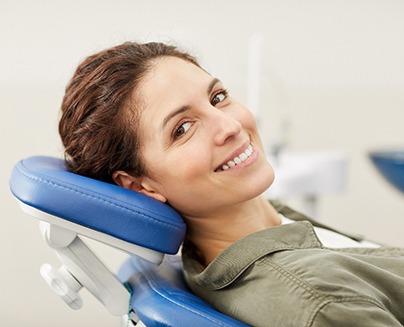 a woman sitting in a dental chair and smiling