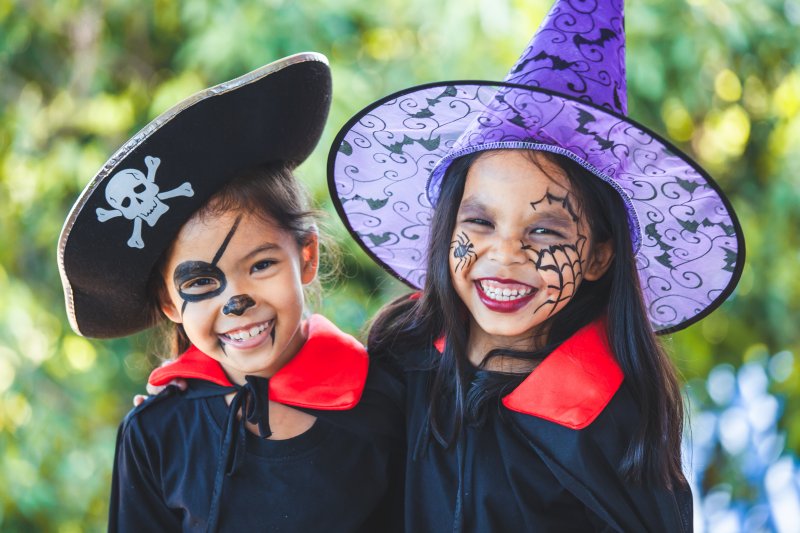 two young girls in Halloween costumes smiling