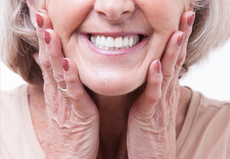 woman smiling while wearing dentures
